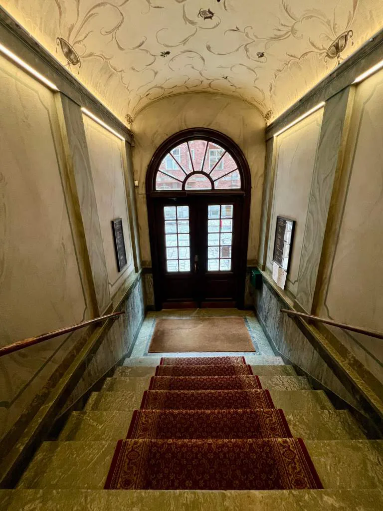Green marble entrance with red carpet on stairs 